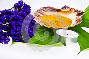 Spa set concept with turmeric powder in seashell decorated with