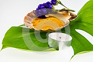 Spa set concept with turmeric powder in seashell decorated with