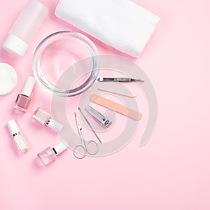 Spa set, manicure or pedicure equipment with nail coat or polish, on a pink background, square format, top view