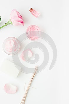 Spa set with rose flowers and cosmetic for body on white desk background top view mockup