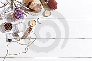 Spa set with sea salt, essential oil, soap and towel decorated with dry flower on white wooden background