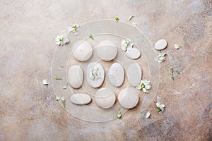 Spa setting for body care and relaxation with flowers on stone background top view. Flat lay.