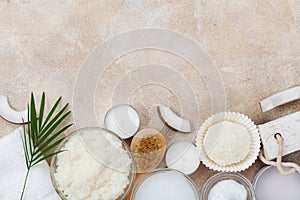 Spa setting from body care, wellness and beauty treatment. Coconut scrub, oil and cream on stone table top view. Flat lay.