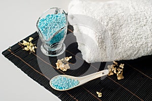 Spa setting with flower and towel on a bamboo black background.