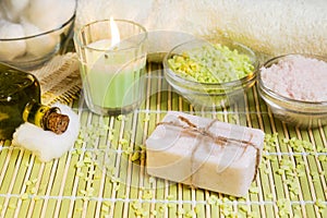 Spa setting with natural soap, olive oil, bath salts and candle.