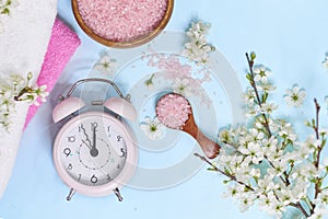 Spa setting spring flowers with towel ,salt in bowl, Spring Time Change, Spring flowers and Alarm Clock.