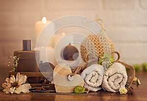 Spa setting with towels, oil and wooden heart on white bricks background