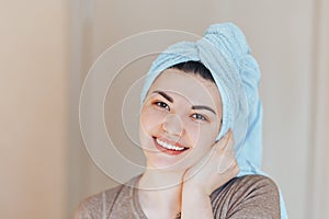 Spa skin care beauty woman wearing hair towel after beauty treatment. Beautiful young woman with perfect skin smiling looking at