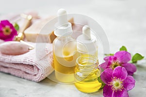 Spa skincare setting with oils and natural soap, rosehip oils and flowers