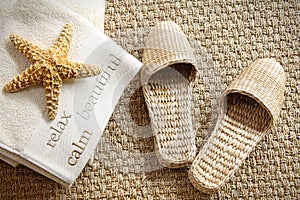 Spa slippers on seagrass carpet with towels