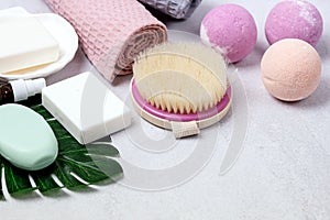 SPA Still Life Background Pink and Light Orange Bath Bombs Soaps Cosmetic Oil on Light Gray Background Washing Brush Gray Towel