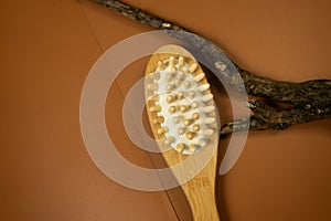 spa still life with brush. wooden brush for anticellulite massage on a brown table. still life