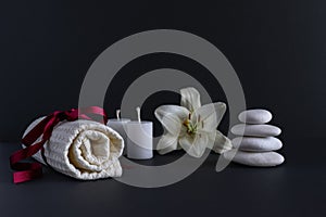 Spa still life with scented candles, stones, flowers and a bath towel