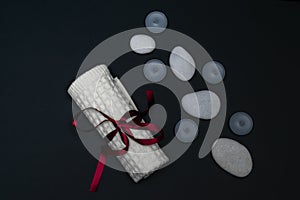 Spa still life with scented candles, stones, a towel for facial treatments on a dark background