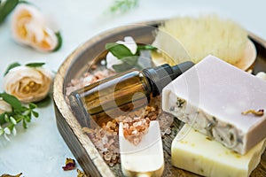 Spa still life setting with natural soaps and oil bottle, bath salt and roses, clean beauty