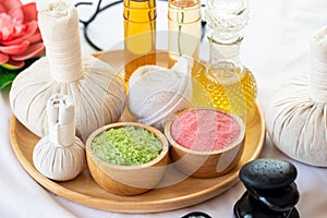 Spa still life with stack of stones, compress, aroma lotion and salt on wooden tray