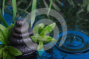 Spa still life with stone pyramid reflecting in water