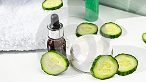 Spa still life with towels. The concept of home skin care. A green cucumber for making a cosmetic mask and a brush