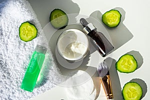 Spa still life with towels. The concept of home skin care. A green cucumber for making a cosmetic mask and a brush with a towel on