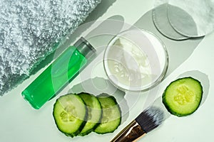 Spa still life with towels. The concept of home skin care. A green cucumber for making a cosmetic mask and a brush with a towel