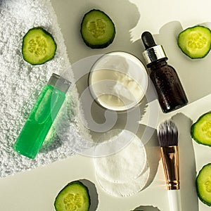 Spa still life with towels. The concept of home skin care. A green cucumber for making a cosmetic mask and a brush with a towel