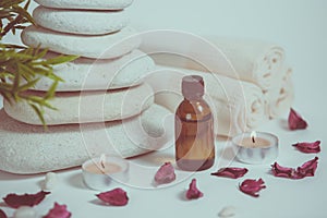 Spa still life with towels, stones, bath oil and candle