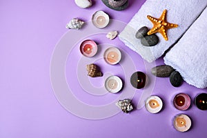 Spa still life treatment with candles, stones, sea shells starfish and towels on pink background