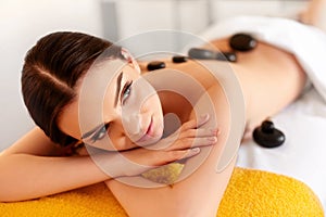 Spa Stone Massage. Young Woman Have Hot Stone Massage Treatments