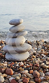 Spa stones balance on the sand of the beach.
