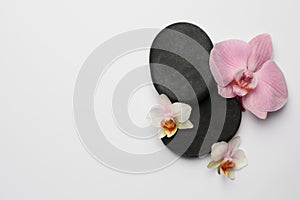 Spa stones and beautiful flowers on white background. Space for text