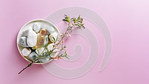 Spa stones, bottle with essential oil and a flowering branch of almonds.