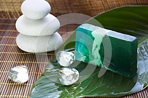 Spa stones, leaf and soap on bamboo mat