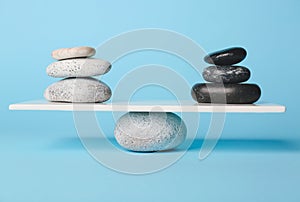 Spa stones on teeterboard against color background. Concept of balance