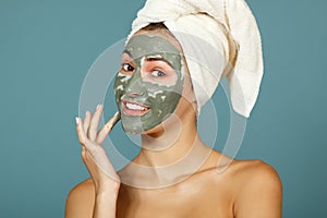 Spa teen girl applying facial clay mask. Beauty treatments.