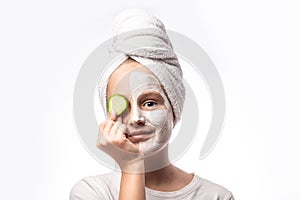 Spa teen girl applying facial clay mask and cucumbers on eyes isolated on white background. Healthy beauty clean treatment and