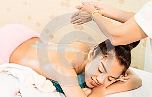 Spa Therapist is applying scrub on to a woman back