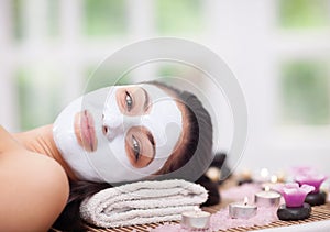 Spa therapy for young woman having facial mask at beauty salon