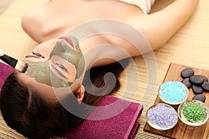 Spa therapy for young woman having facial mask at beauty salon - indoors