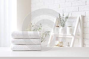Spa towel stack on white table on bathroom interior background