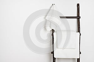 Spa towels hanging on vintage wooden stepladder isolated on white