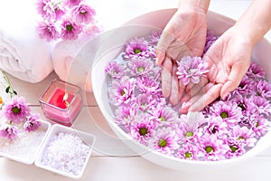Spa treatment and massage product for female feet and manicure nails spa with pink flower.