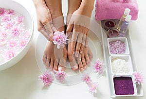 Spa treatment and product for female feet and manicure nails spa with pink flower, copy space,
