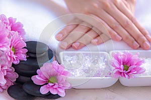 Spa treatment and product for female feet and manicure nails spa with rock and pink flower, copy space, select focus,