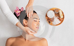 Spa Treatment. Relaxed Asian Lady Enjoying Face Massage And Aromatherapy In Salon