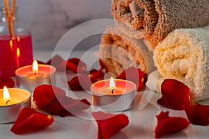 Spa treatment set with scented oil, candles, rose petals and flowers