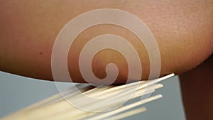 Spa treatments anti-cellulite massage with bamboo brooms. The therapist massages the woman's back with bamboo sticks to