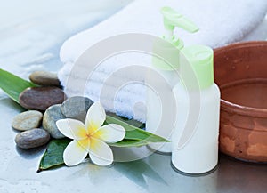 Spa or wellness background with white towels, tropical leaves, flowers, body and face care tools and accessories on white