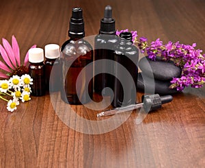 Spa and wellness setting with flowers and glass cosmetic bottles stock images