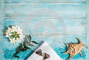 Spa and wellness setting with flowers, and white towel on old wooden background. Blue dayspa nature set. copyspace. Vacation