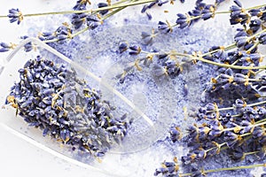 Spa and wellness setting with lavender flowers, sea salt, oil in a bottle, aroma candle on wooden white background